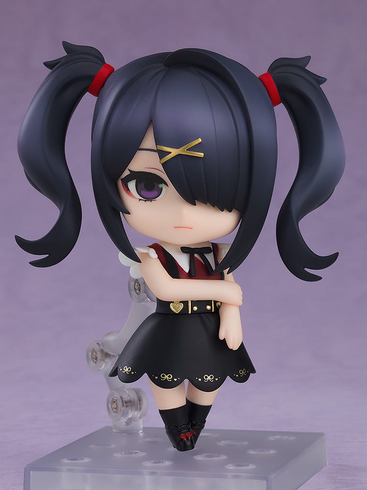 Nendoroid figure of a dark-haired girl with twin pigtails and a gold X clip, pouting in a black dress with arms crossed