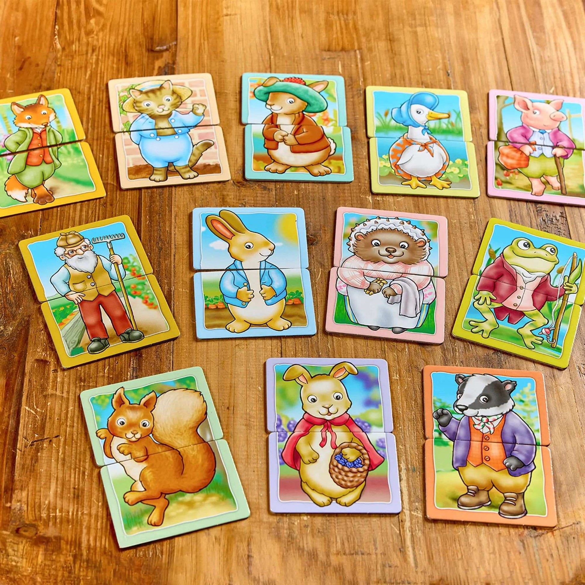 An assortment of Orchard Peter Rabbit Heads and Tails character puzzles depicting various animals and an old man on a wooden background