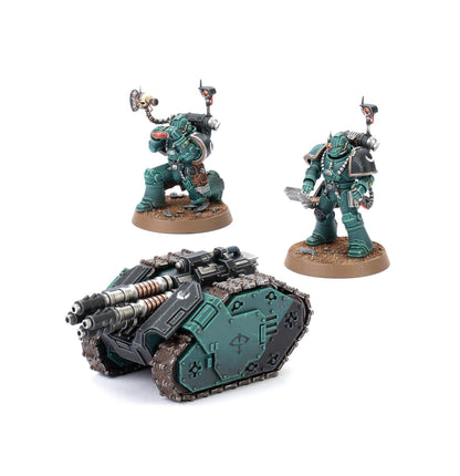 A Legiones Astartes Rapier Laser Destroyer tank model and two armored figures in dark teal and black, one kneeling with a skull-mounted camera and one standing with a sword
