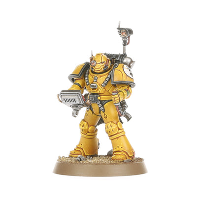 A painted yellow armored miniature figure resembling a space marine holding a scanner with a backpack and antenna, standing on a textured base