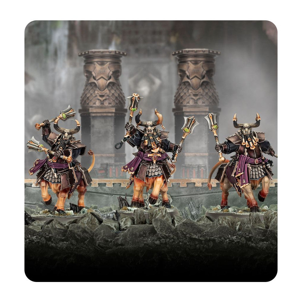 Three dark fantasy Bull Centaur miniatures, heavily armored and wielding dual axes with glowing green gems, stand ready for battle on rocky ground