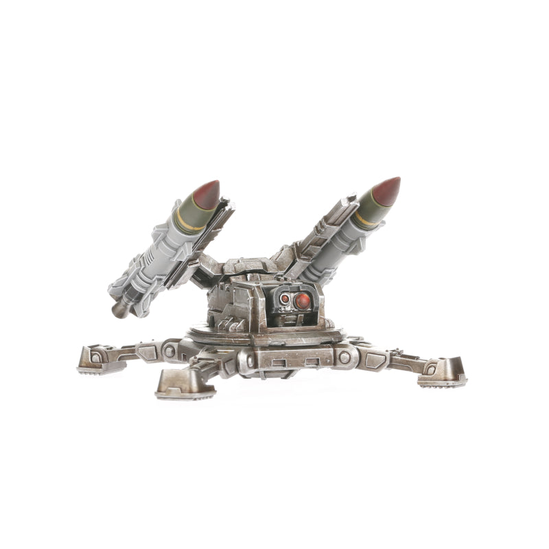 A Legiones Astartes Tarantula Missile Battery miniature, a gray and bronze weapon platform with two missiles angled upwards and red sensor eyes