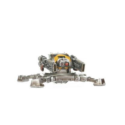 A Legiones Astartes Tarantula Sentry Gun miniature, grey and yellow, with twin cannons on a multi-legged base