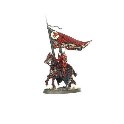This miniature shows a standard-bearing vampire cavalry unit, dressed in deep crimson armor, riding an armored warhorse and carrying a large flag emblazoned with a red dragon over a dark moon