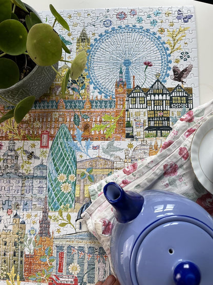 Close-up of a blue teapot and potted plant on a completed London landmark jigsaw puzzle illustration