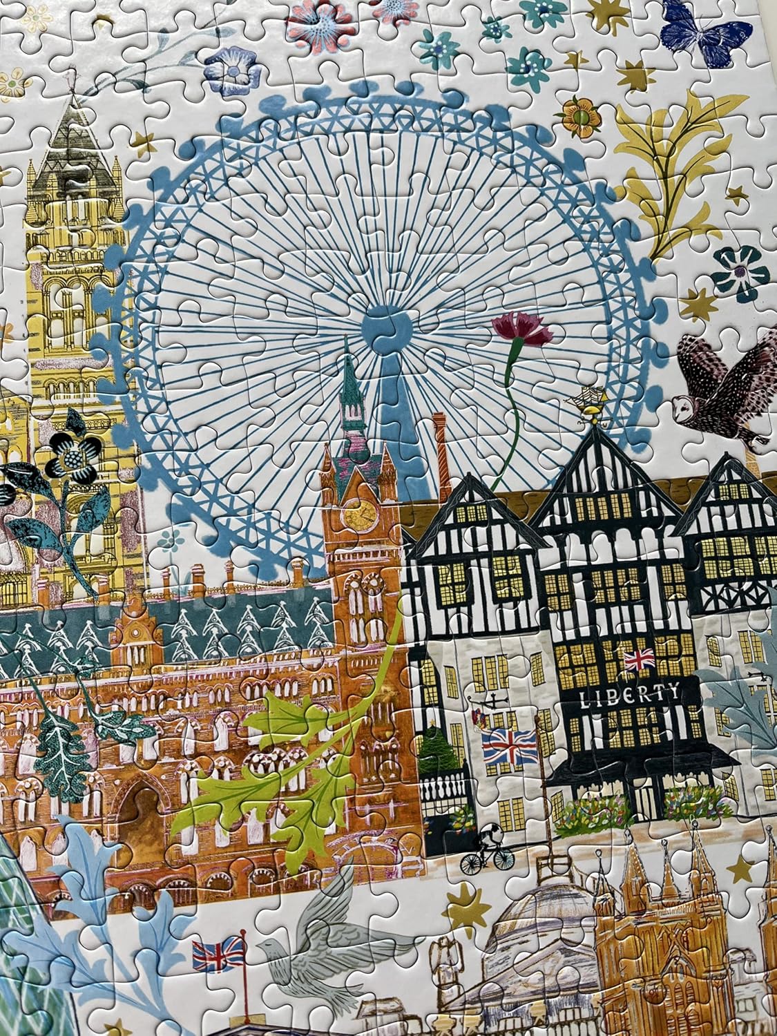 Detailed jigsaw puzzle image of London landmarks, including the London Eye and Liberty store, with decorative plants