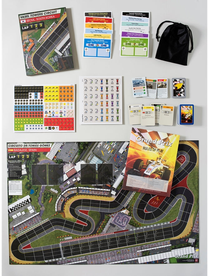 Overhead view of a Grand Prix board game set, featuring a race track board, cards, tokens and rulebook