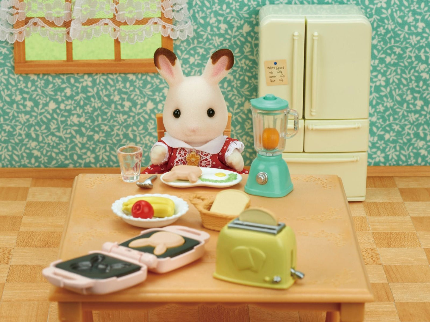 Miniature rabbit doll eating breakfast at a table with tiny toaster, blender, and waffle maker