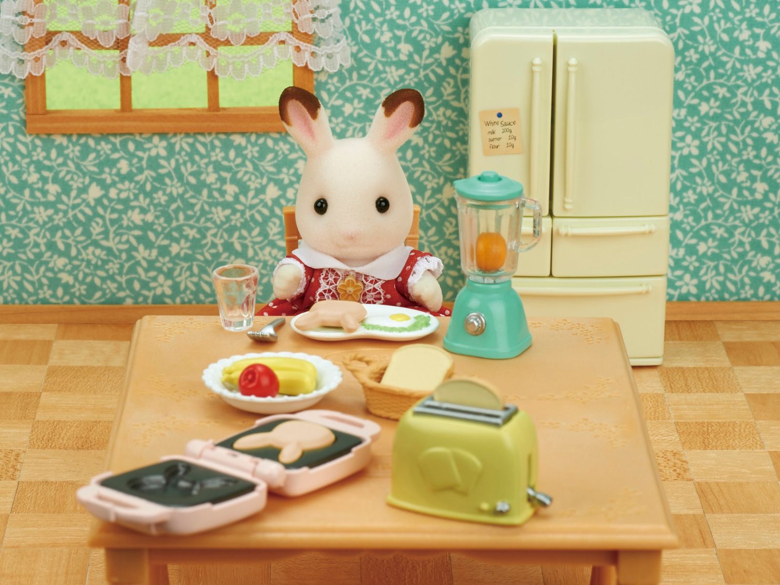 Miniature rabbit doll eating breakfast at a table with tiny toaster, blender, and waffle maker