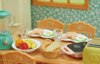 Close-up of a miniature dollhouse breakfast set on a table, including bunny pancakes and a teal blender