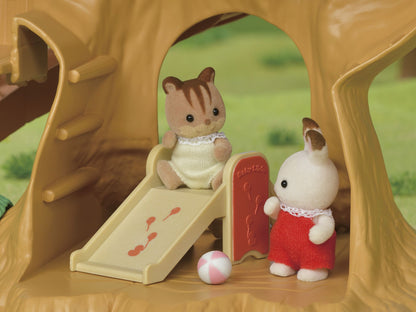 Flocked animal toys playing on a small playground slide within a tree playset