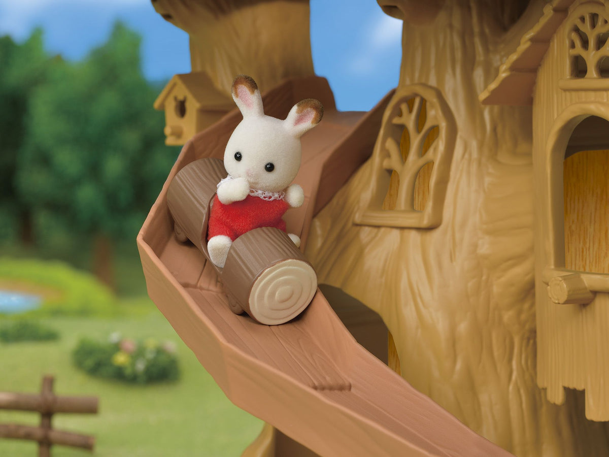 Flocked rabbit figure in red slides down a brown log ride chute on a treehouse playset