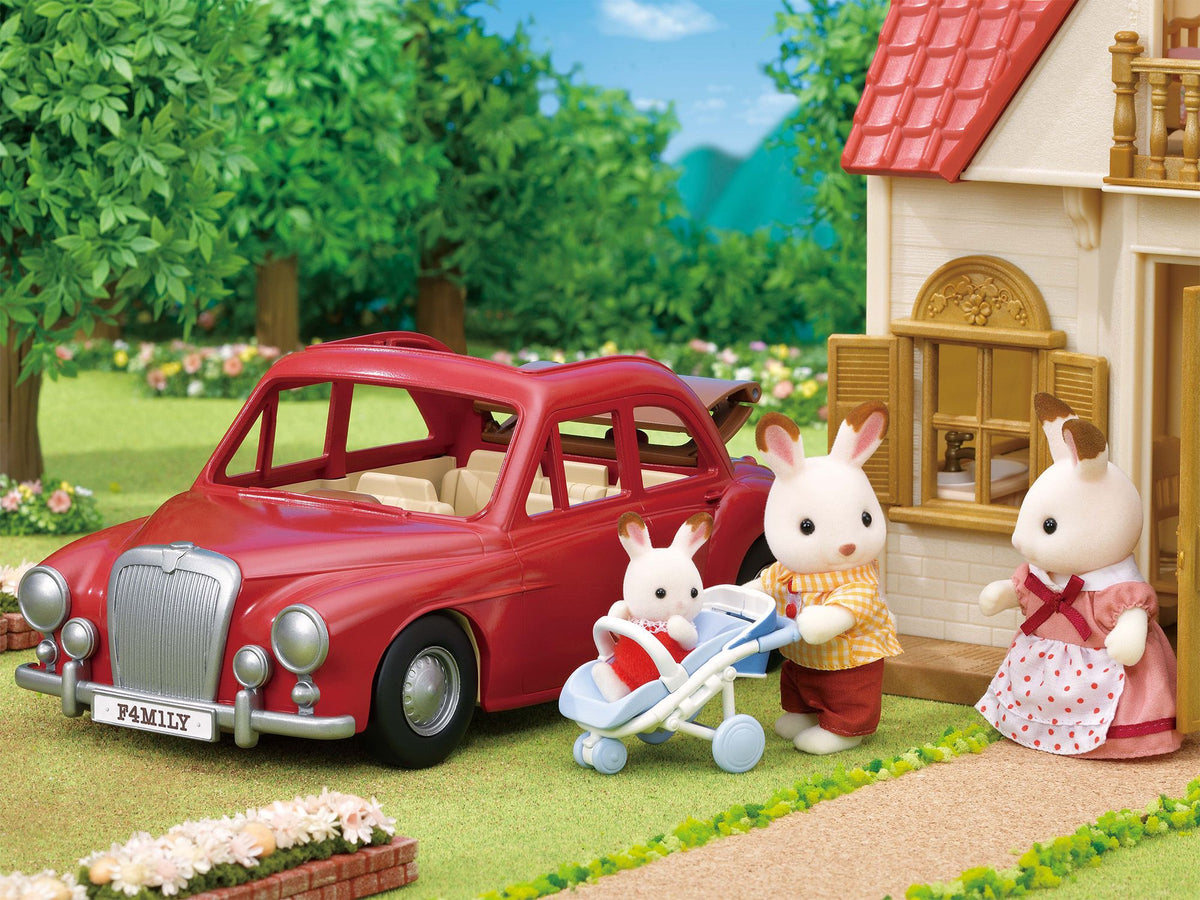 Sylvanian Families rabbit family with a baby in a stroller next to a red classic car and house