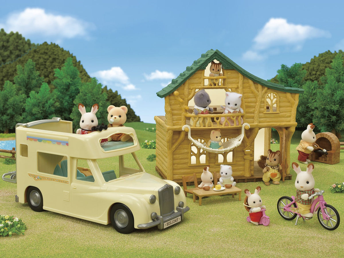 Sylvanian Families on a camping holiday near a log cabin and RV. Critters are biking, grilling, and relaxing