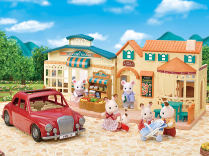 Sylvanian Families scene: Critter families near a red car, grocery market, and village pizzeria playset