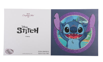 Craft Buddy's DIY Crystal Art Stitch card kit displays a vibrant rhinestone mosaic of the grinning blue alien inside a thick purple crystal border