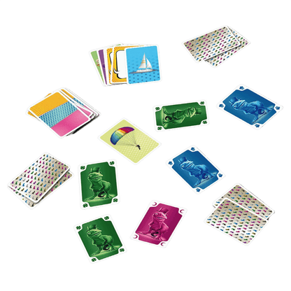 One of Us playing cards are scattered on a green background, showing various colorful designs, a sailboat, a parachute, and dinosaurs in top hats