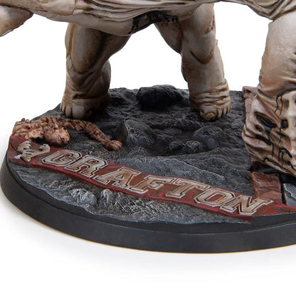 Close-up of a monster figure base, showing pale feet, rocky terrain, and a banner with the word "GRAFTON"