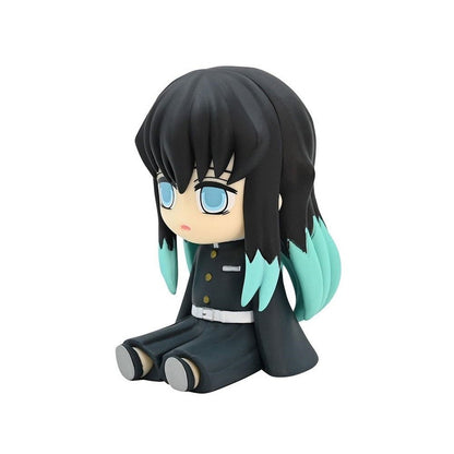 Chibi anime figure of a dark-haired girl with teal hair accents wearing a dark uniform and sitting