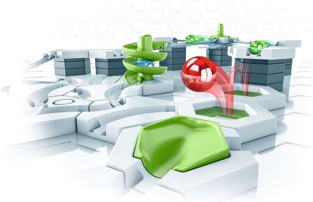 Modular marble run toy with green ramps and white blocks; a shiny red ball bounces toward a catcher