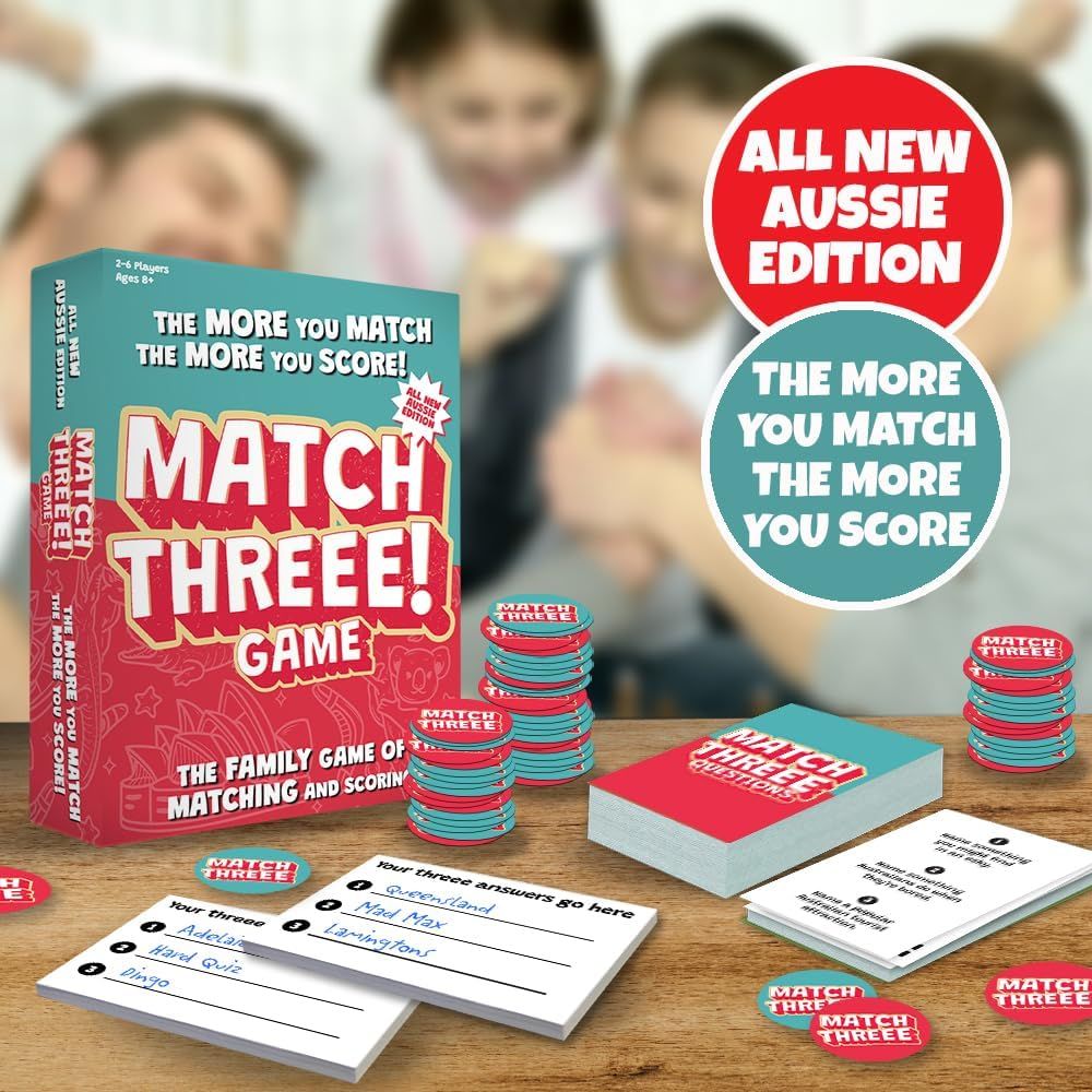Match Threee! Aussie Edition board game box, chips, and cards displayed on a table, with people blurred in the background enjoying the game