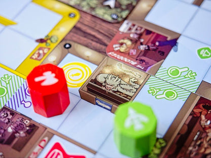 A close-up view of the Magic Maze Pocket board game setup displaying modular tiles and two hexagonal tokens, a prominent red one marked with an axe and a blurry green piece