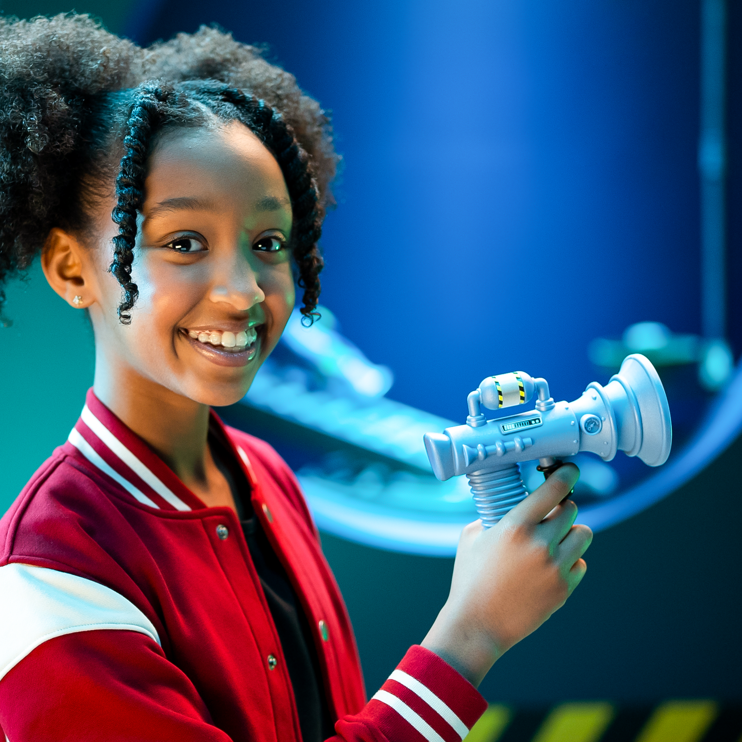 A cheerful girl holds the light blue Moose Despicable Me 4 Mini Fart Blaster featuring a distinct striped gas tank and ribbed handle