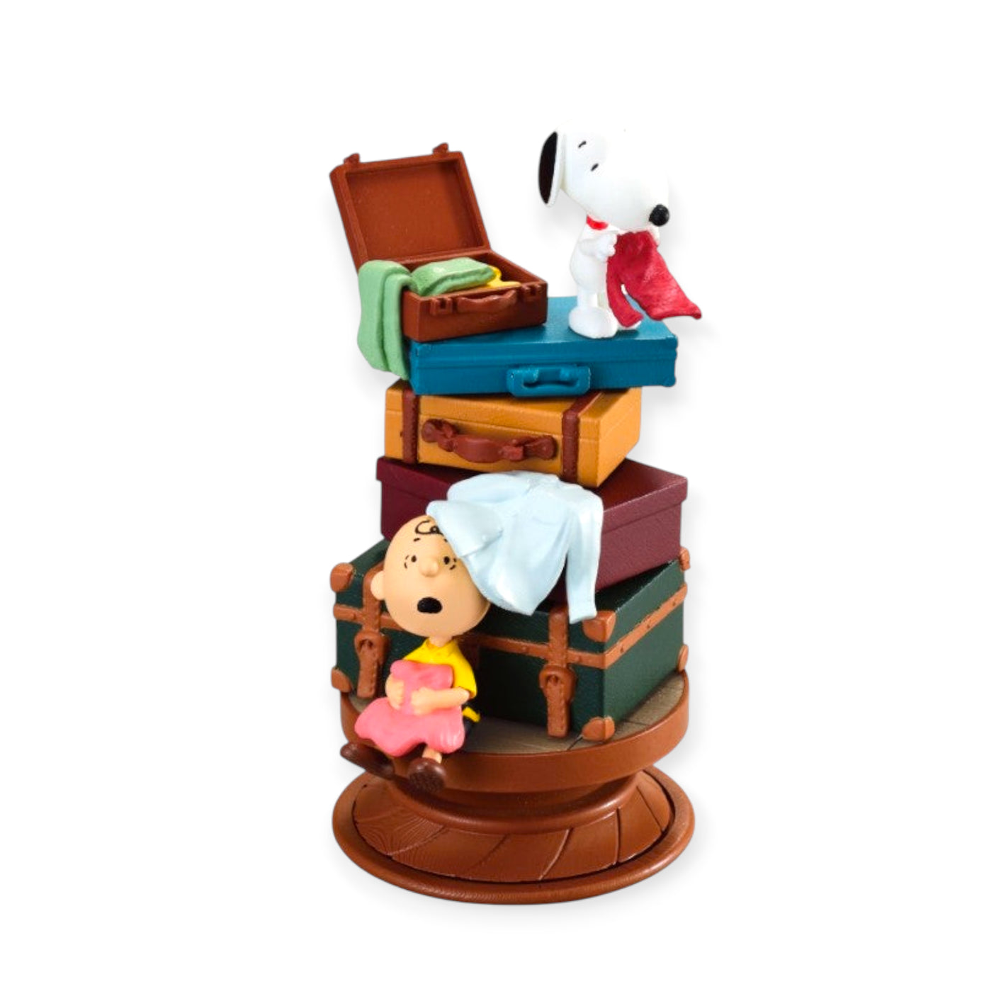 Snoopy and Sally Brown figurine standing on a precarious stack of five colourful travel suitcases