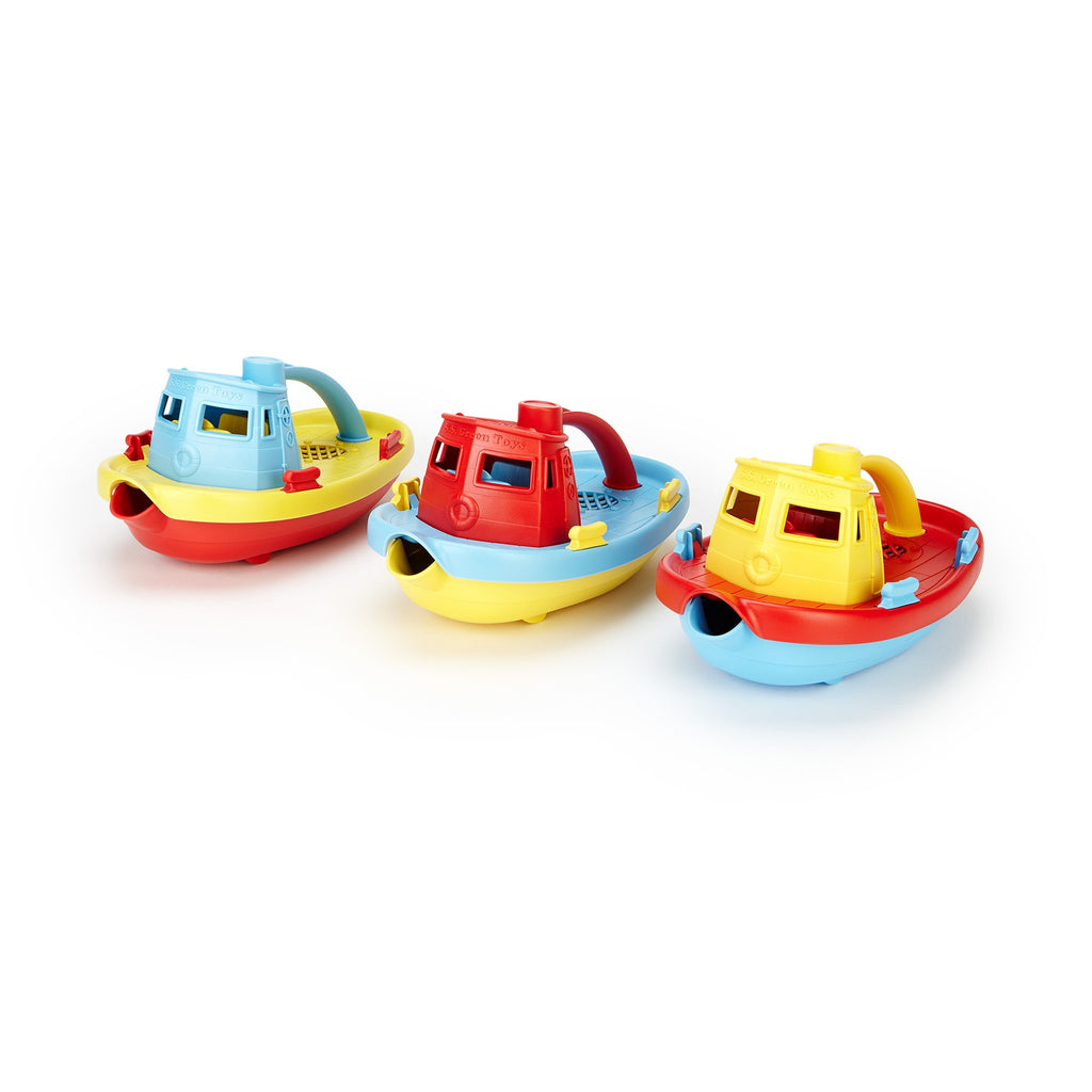 Three colourful plastic toy tugboats in red, yellow, and blue, lined up on a white background