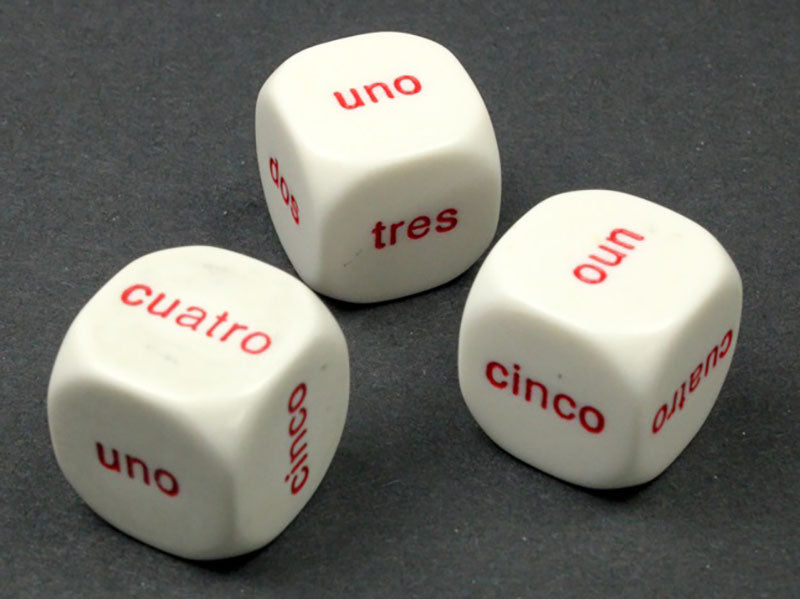 Three white 6 sided dice with red 1-6 Spanish Word showing on a grey background