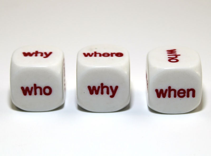 Three white dice in a row showing red question words: 'who,' 'why,' 'where,' and 'when' on their faces 