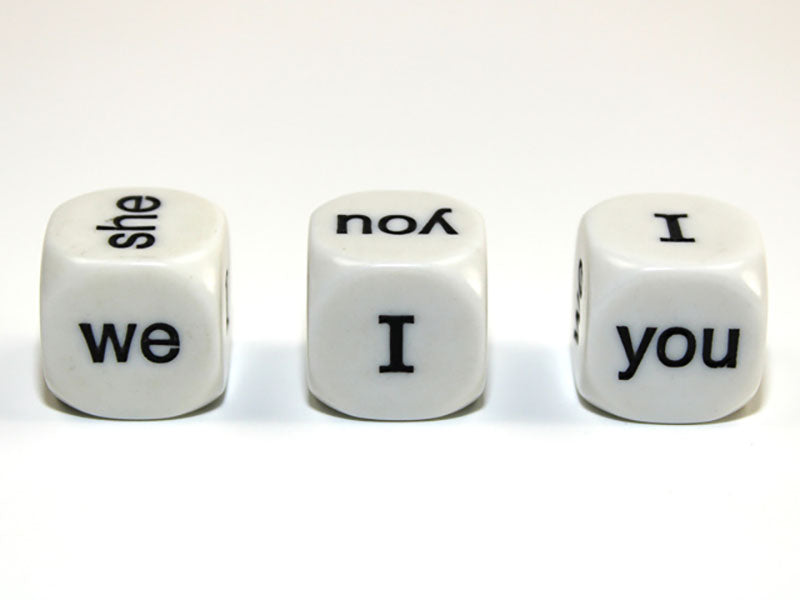 Three white 6 sided dice with black English Pronoun showing on a white background