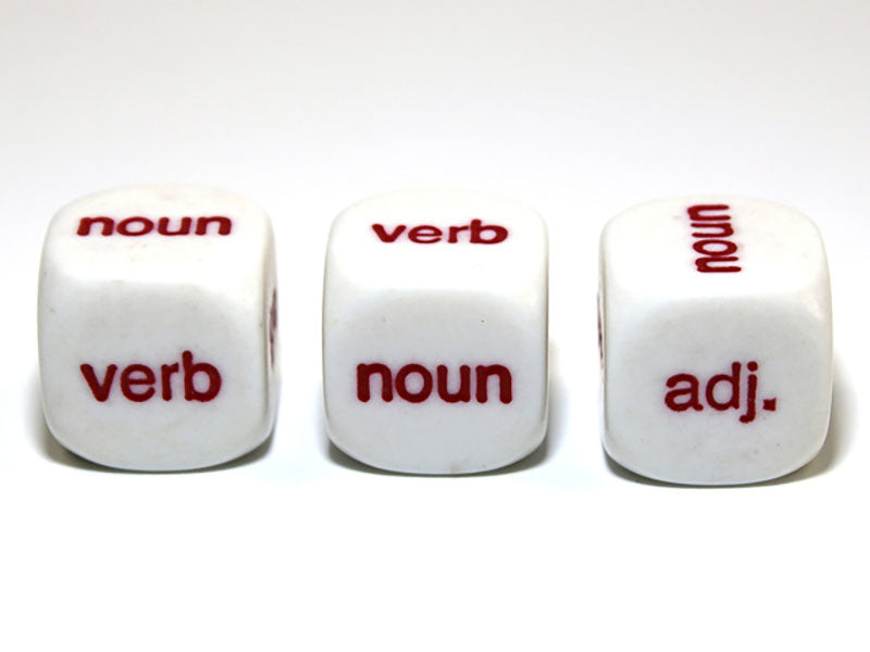 Three white grammar dice with red text: 'noun', 'verb', 'adjective' on their visible faces, against a plain white background 