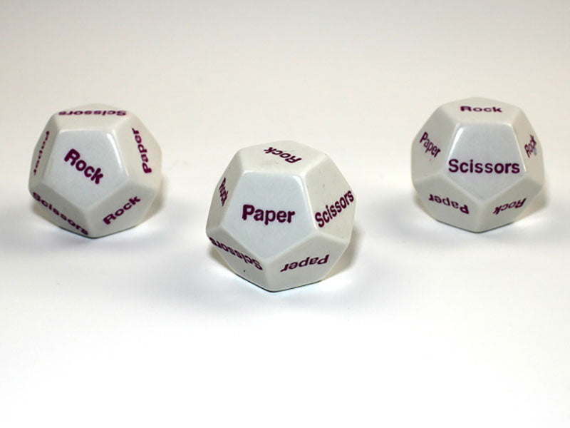 Three white 12 sided dice with purple Rock Paper Scissors showing on a white background