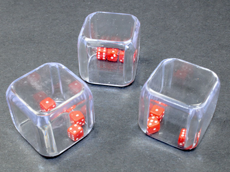 Three clear square containers, each holding red dice with white pips, on a dark surface 