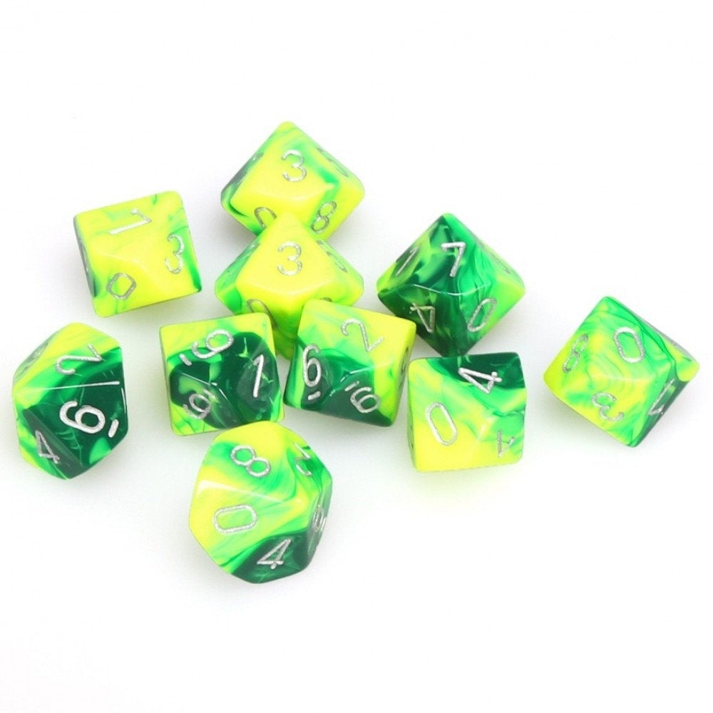 A set of 10 green and yellow swirled d10 dice with silver numbers scattered on a white surface