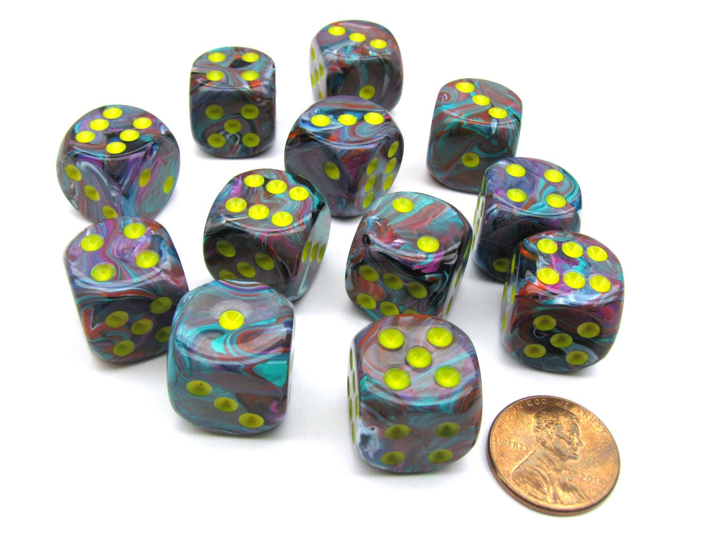 Twelve 16mm Chessex Festive Mosaic/Yellow D6 dice with swirled multicolored patterns and vibrant yellow pips are displayed on a white background with a penny for scale