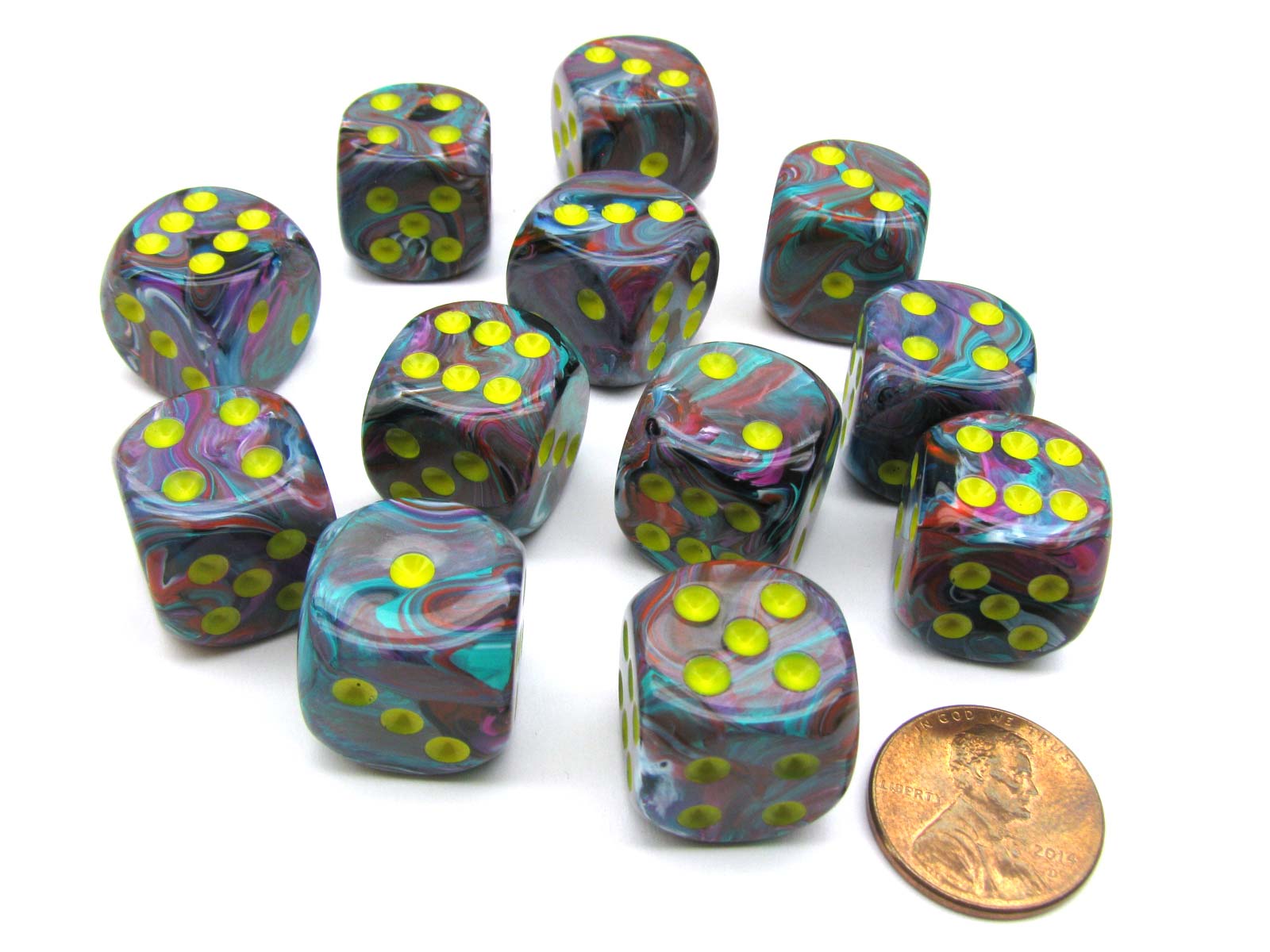 Twelve 16mm Chessex Festive Mosaic/Yellow D6 dice with swirled multicolored patterns and vibrant yellow pips are displayed on a white background with a penny for scale