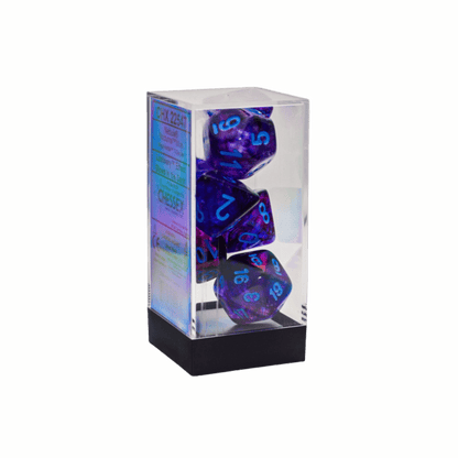 A clear plastic case holds a Chessex Nebula Nocturnalblue Luminary Mega-hedral 7-Die Set of purple dice with blue numbers