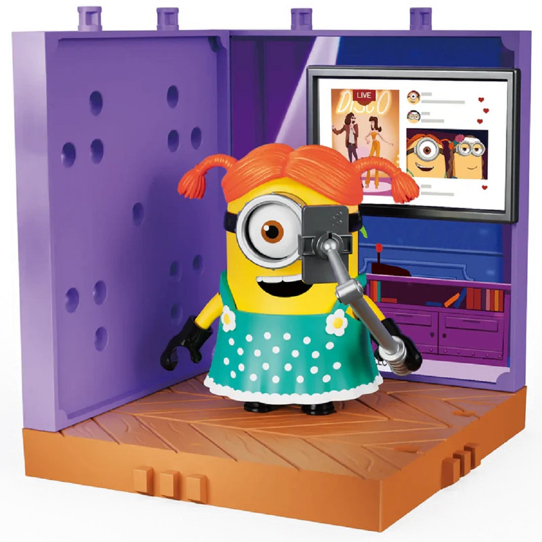 Minion figure in a polka-dot dress and wig takes a selfie using a stick inside a purple room playset