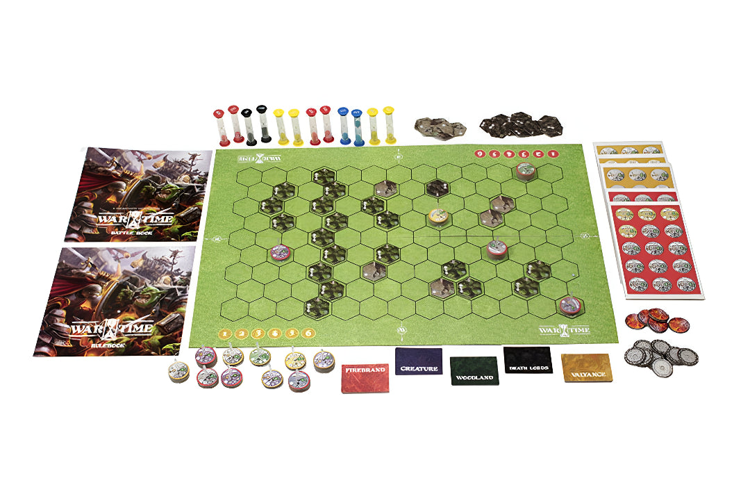 Overhead view of the Wartime: The Battle of Valyance Vale board game components: green hexagonal board, rulebooks, hourglass timers, and various tokens