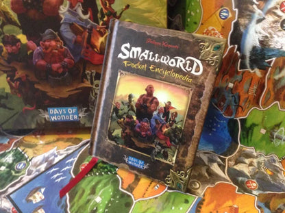 Close-up of Small World components including faction tokens and victory coins