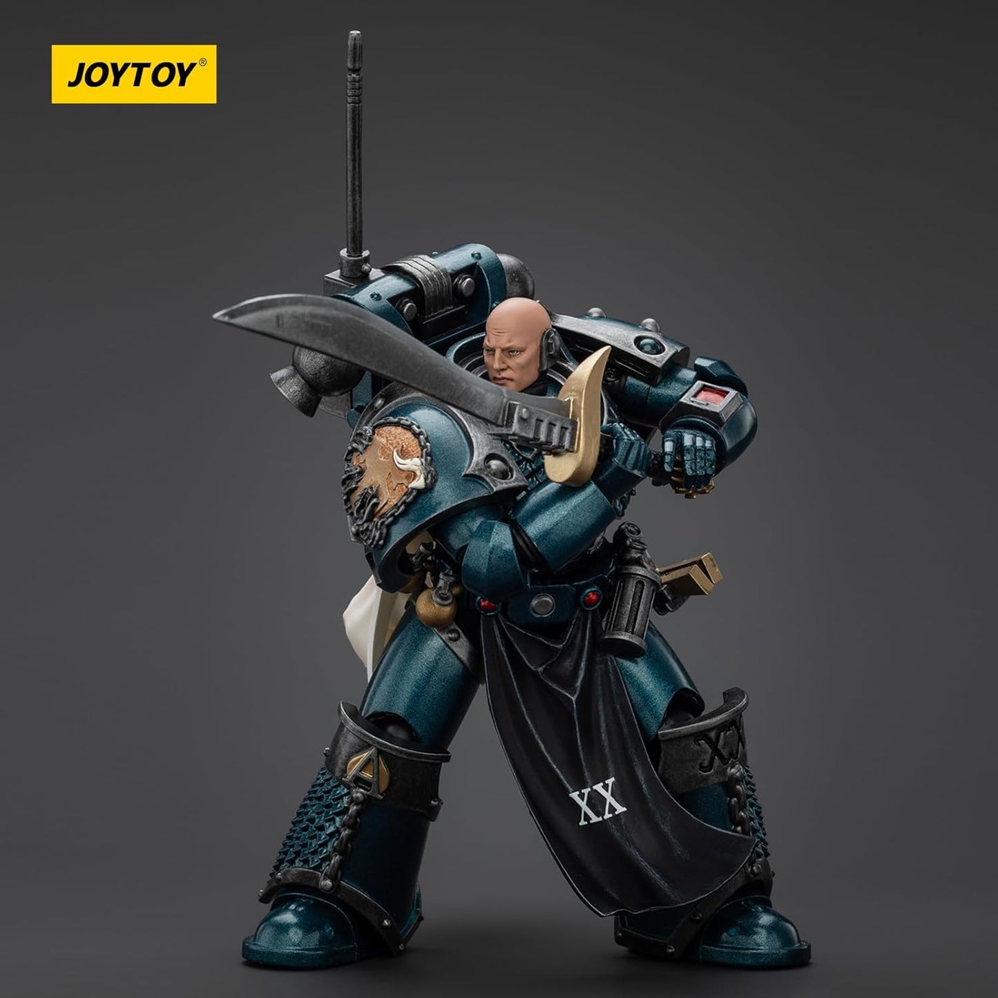 A JOYTOY action figure of a bald, teal-armored warrior holding a large sword across his chest