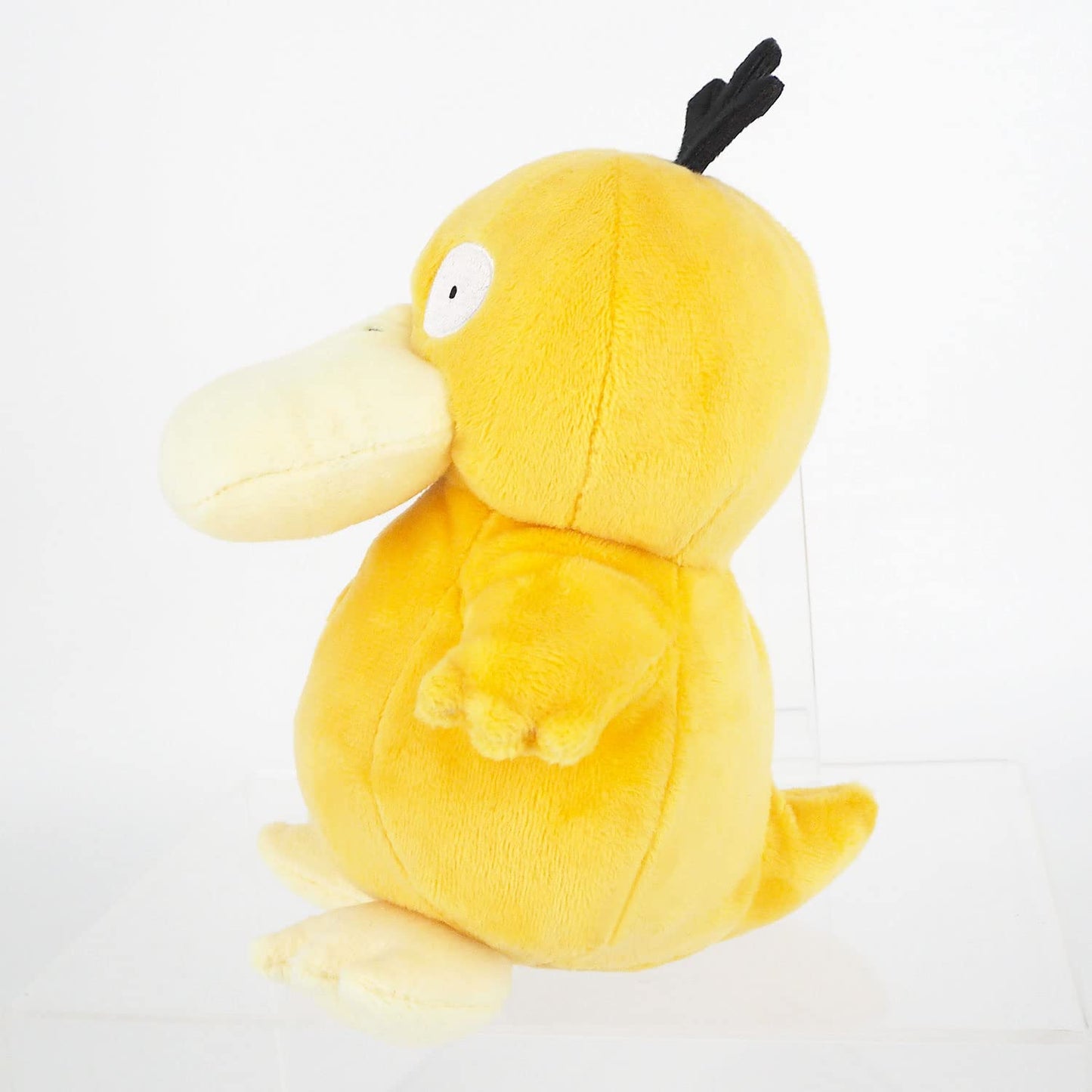 Yellow Pokémon Psyduck plush toy standing in profile against a white background