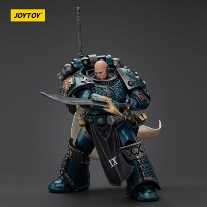 A Joytoy Alpha Legion Space Marine action figure, bald and in dark teal armor, holding a large ornate sword in a ready pose