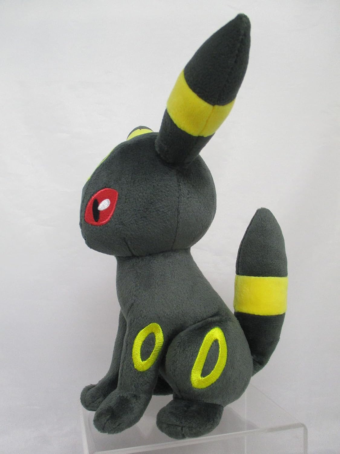 Dark grey Pokémon Umbreon plush sitting, featuring red eyes and bright yellow rings/stripes