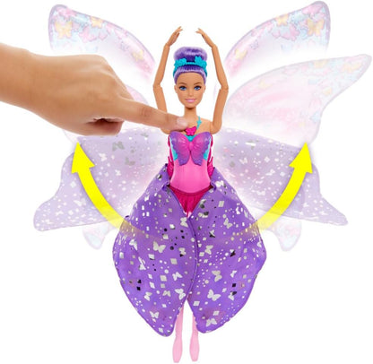A hand presses a purple-haired Barbie doll's chest -  causing her glittery purple skirt-wings to spread open