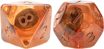 Translucent amber d8 and d10 RPG dice, each encapsulating a dark, textured petrified seed-like object. Visible numbers include 8 and 7