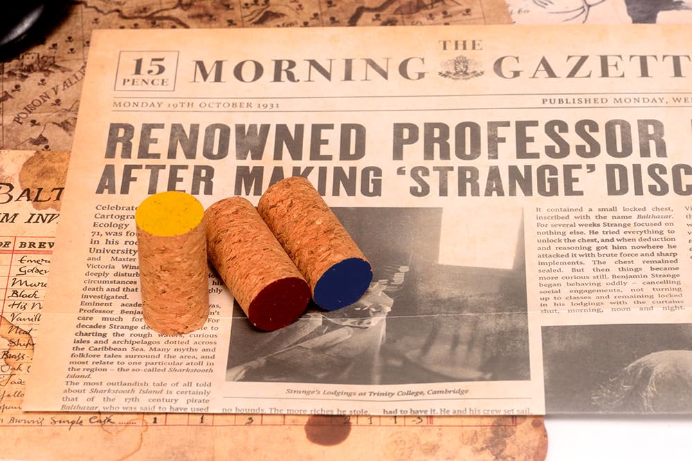 Three corks with yellow, red, and blue tops rest on a vintage newspaper about a &#39;strange&#39; discovery