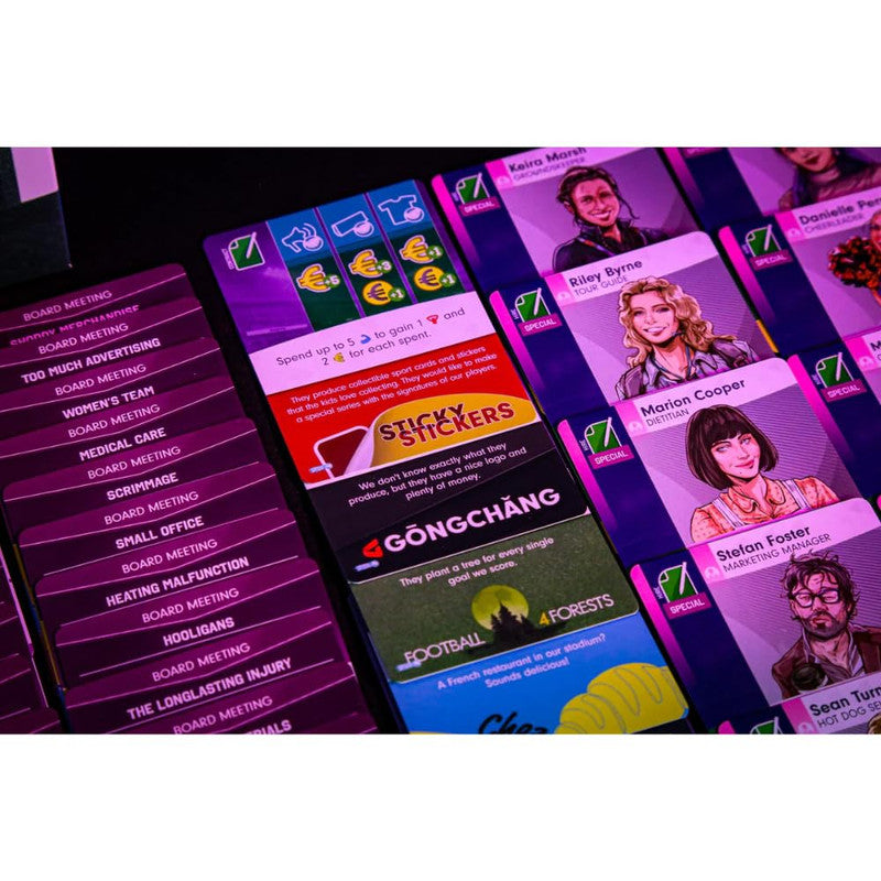 Close-up view of various gameplay cards from a board game set on a black table